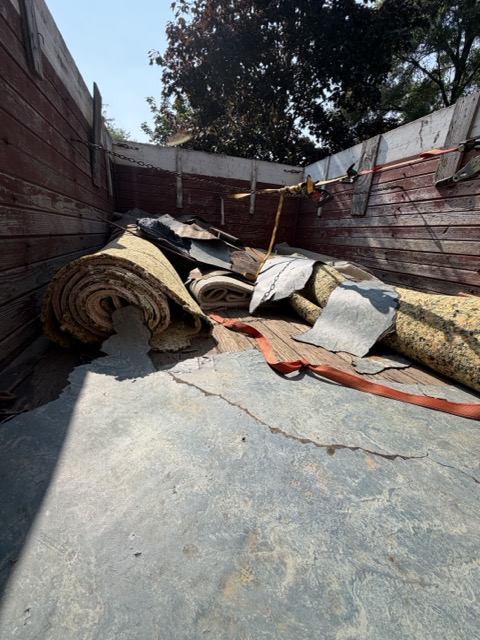 Old carpet and construction debris loaded for hauling and disposal